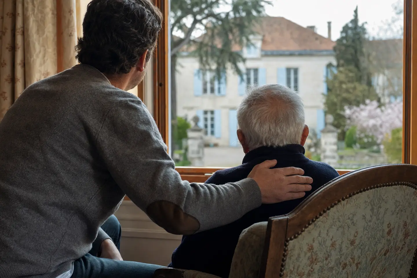 Un homme âgé et son fils rassurés dans le salon familial : l'APA ne met pas en jeu la maison ni l'héritage