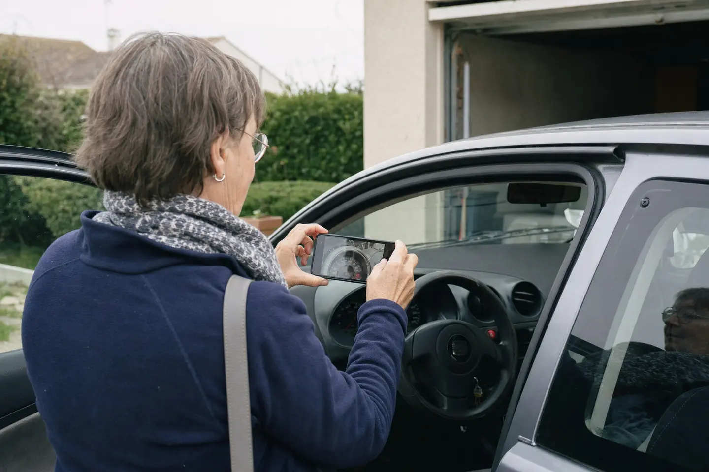 Conductrice photographiant le compteur kilométrique de sa citadine, relevé annuel exigé par l'assurance auto au kilomètre