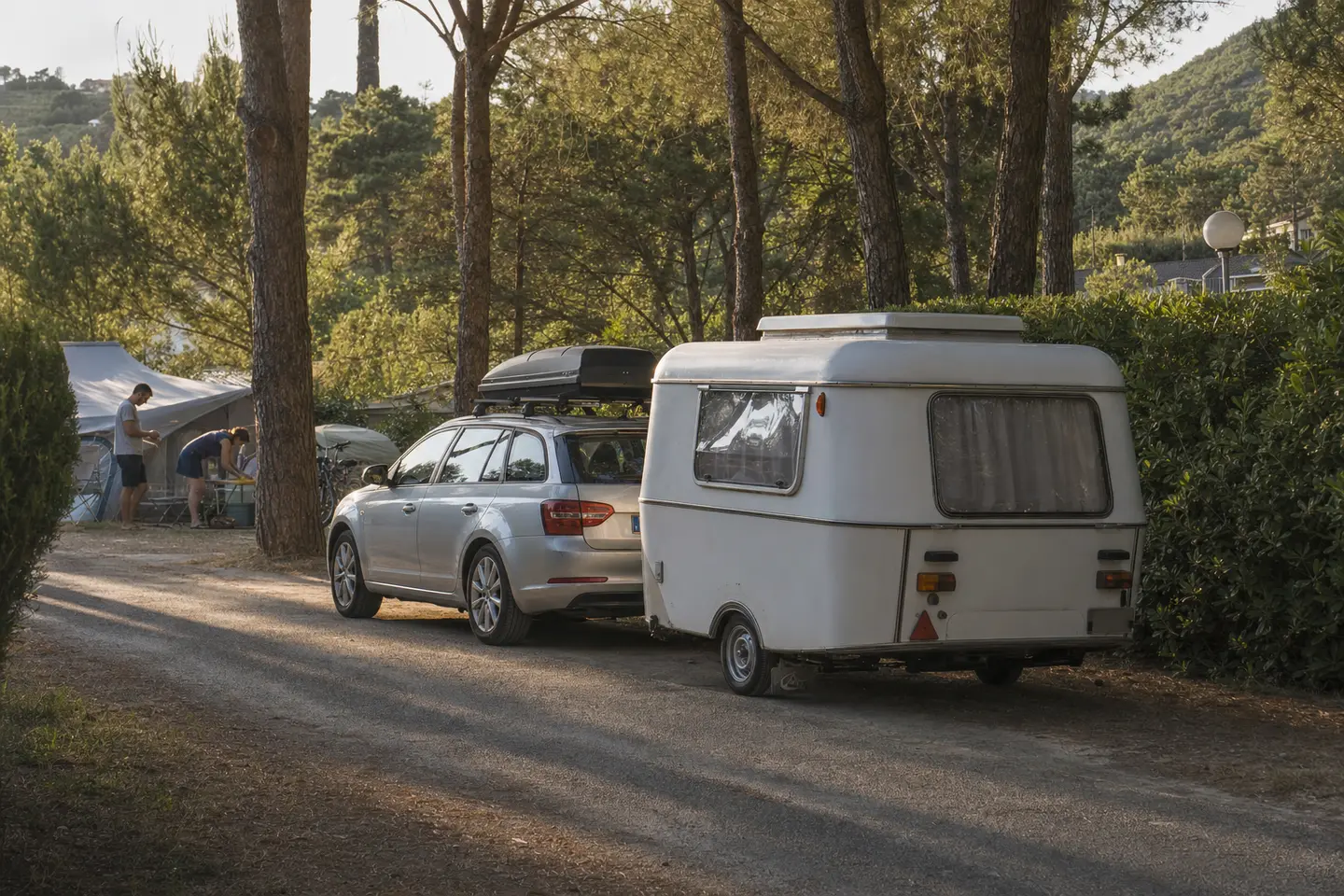 Petite caravane de moins de 750 kg attelée à une voiture familiale à l'entrée d'un camping français