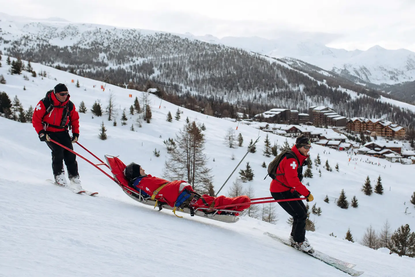 Des pisteurs-secouristes évacuent un skieur blessé en traîneau sur une piste de station française
