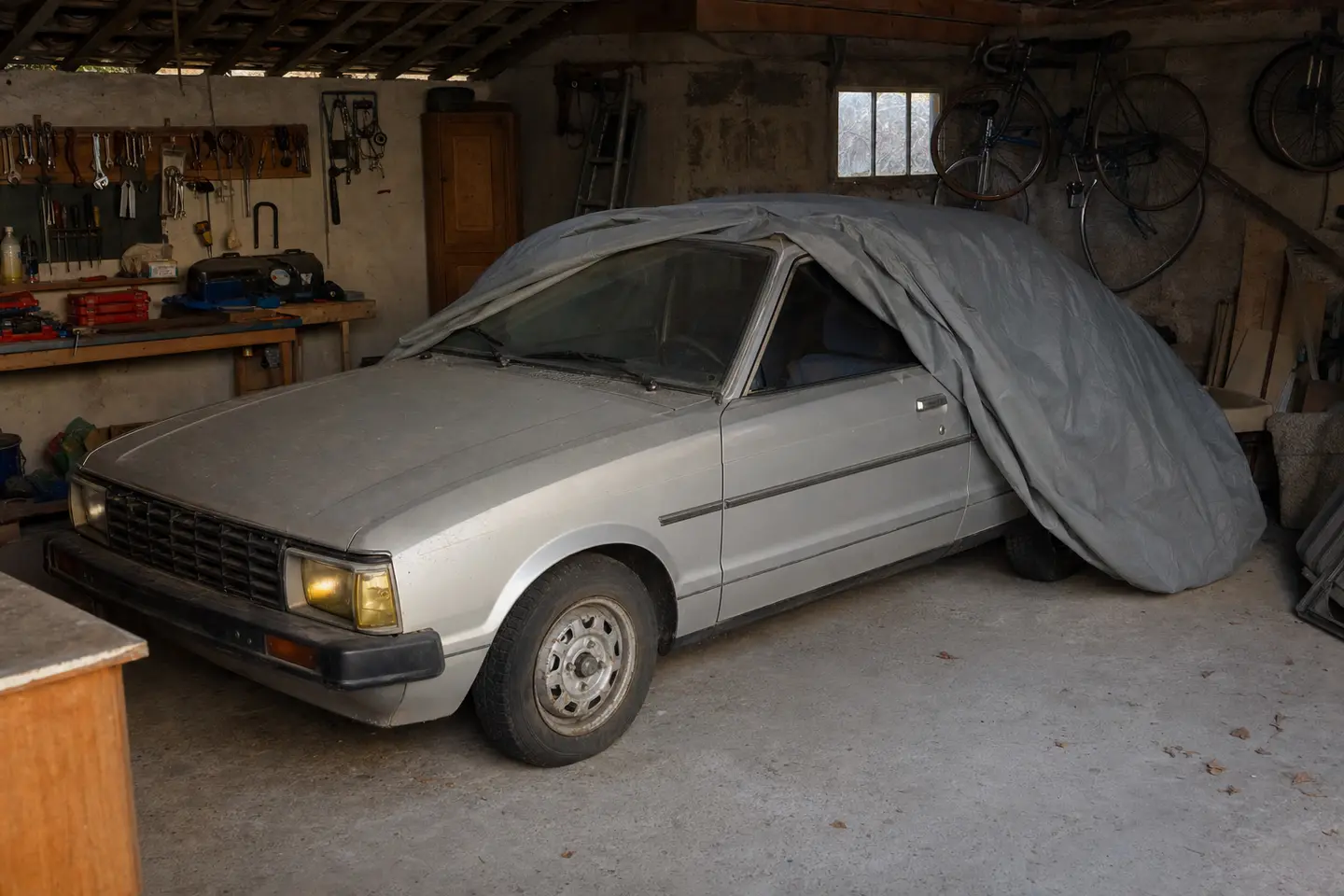 Voiture immobilisée sous une housse dans un garage particulier, un véhicule qui ne roule pas mais reste soumis à l'obligation d'assurance