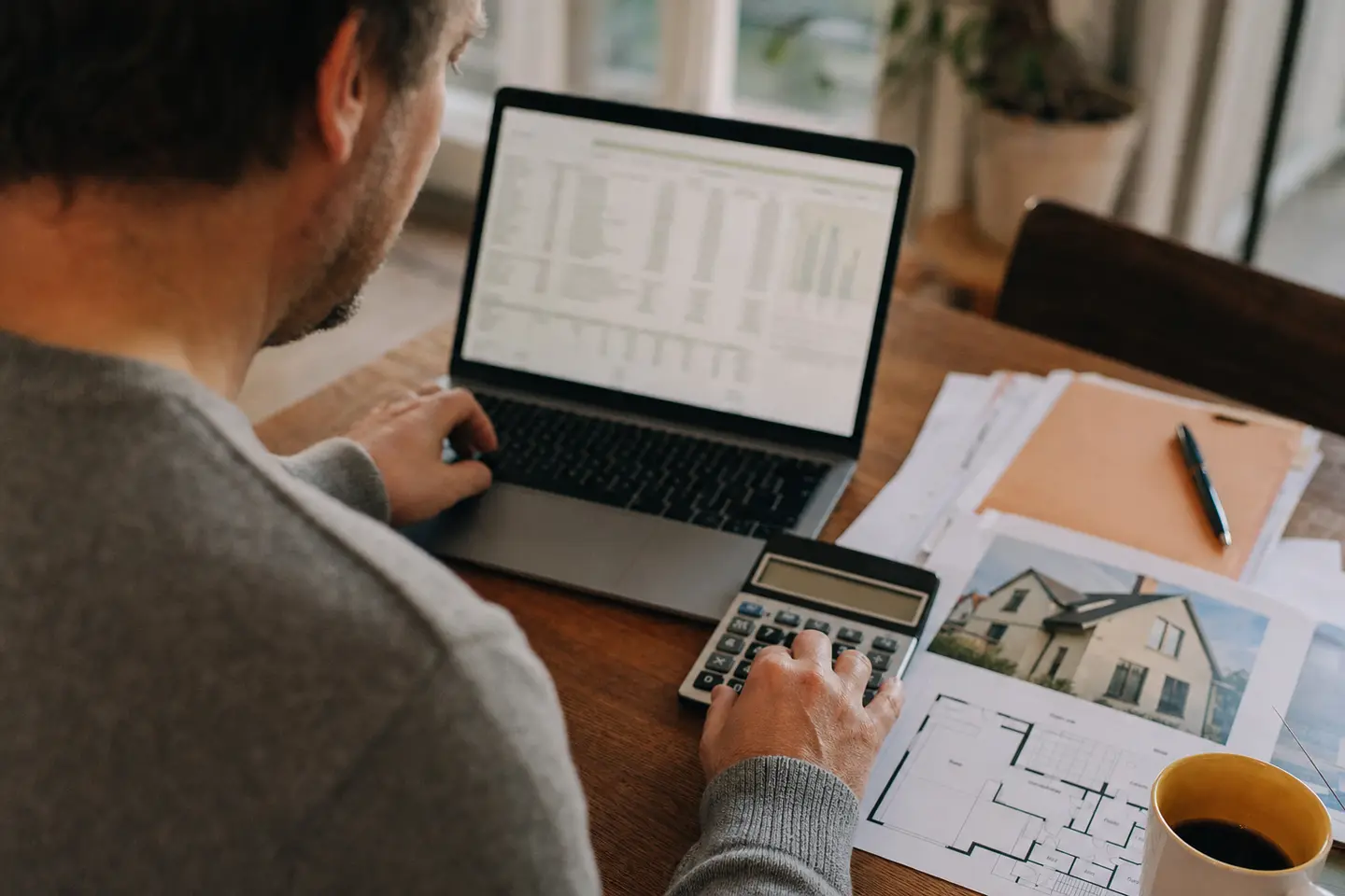 Un emprunteur calcule le coût de son assurance de prêt immobilier à l'aide d'une calculatrice et d'un tableur