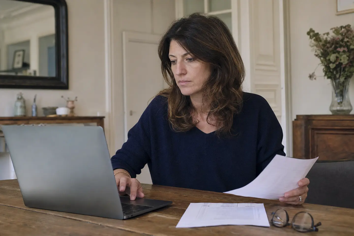 Une femme remplit sa déclaration de revenus en ligne pour reporter les versements de son PER