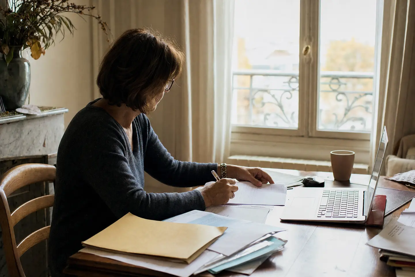 Femme d'une cinquantaine d'années remplissant en ligne une demande de pension de réversion
