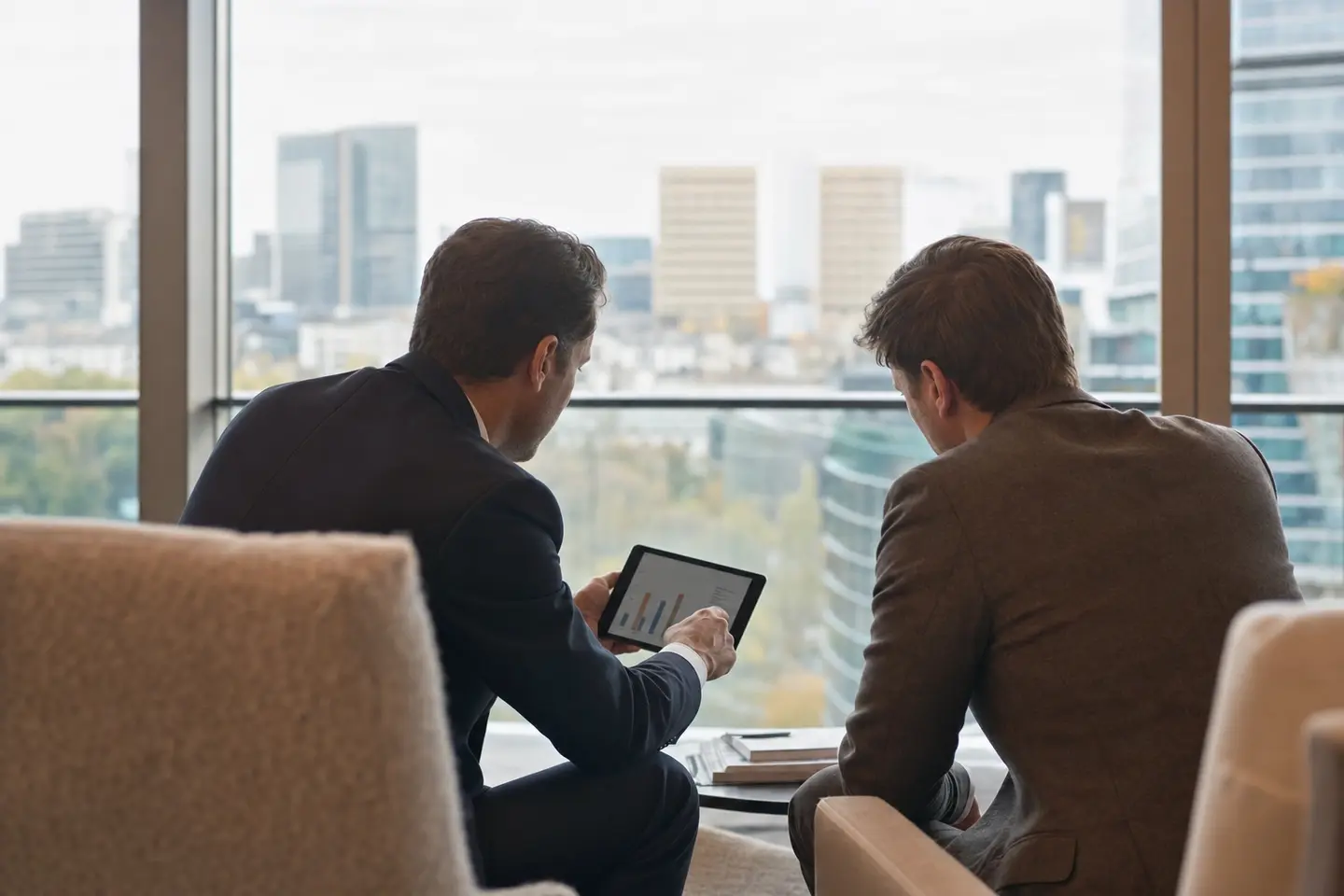 Un gérant privé et son client examinent un portefeuille d'investissement sur une tablette dans un bureau à Luxembourg