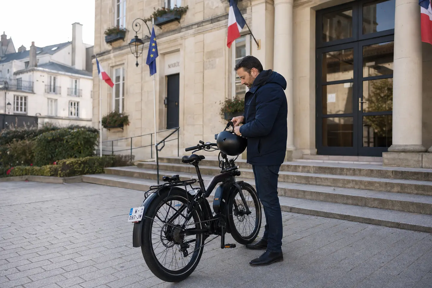 Speed bike équipé de sa plaque d'immatriculation arrière stationné devant une mairie française