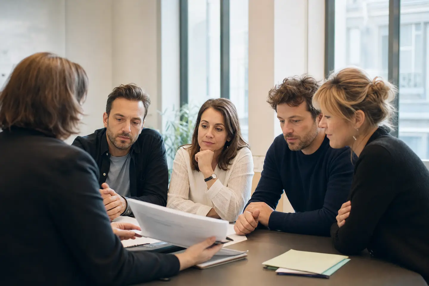 Responsable RH présentant le contrat de complémentaire santé collective à des salariés autour d'une table, illustrant la mutuelle d'entreprise obligatoire