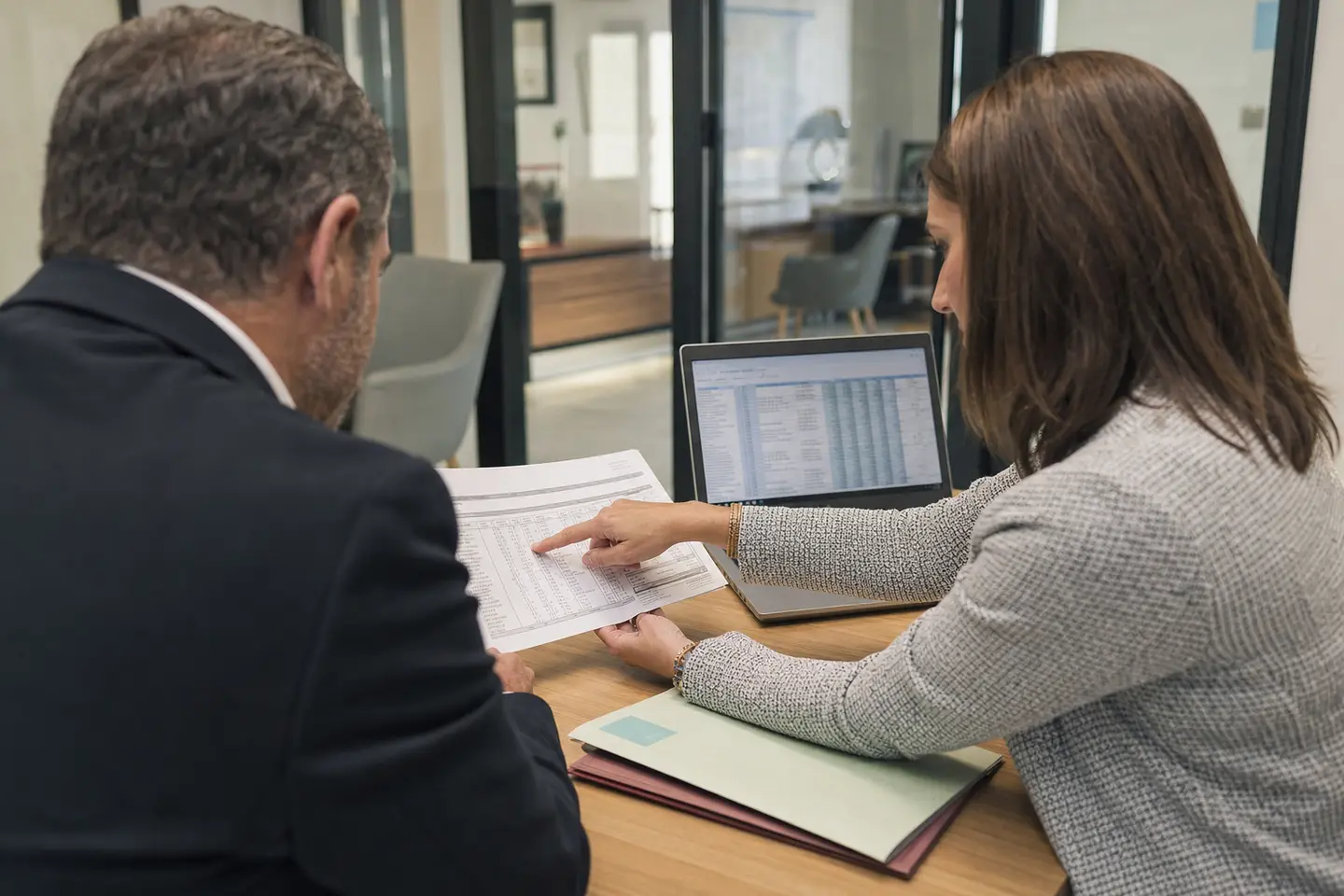 Gestionnaire de paie montrant à un cadre la ligne de cotisation prévoyance tranche A sur son bulletin de salaire
