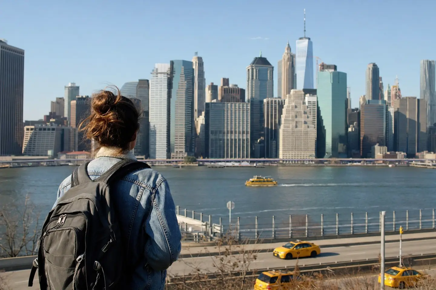Jeune voyageur avec un sac à dos observant les gratte-ciel de Manhattan depuis un point de vue new-yorkais