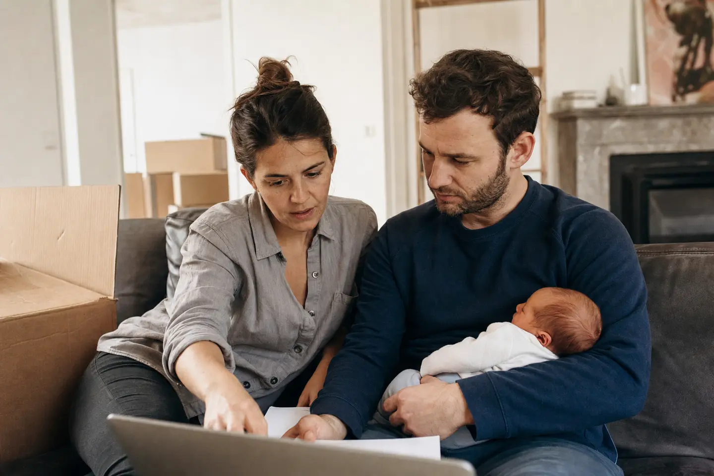 Un couple examine la répartition de la quotité de son assurance emprunteur devant son ordinateur, dans son nouveau logement