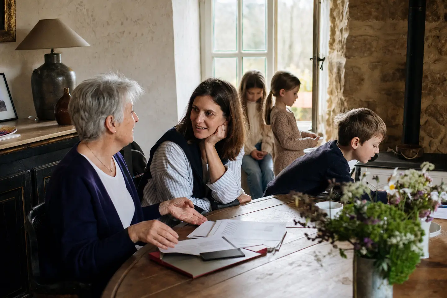 Une famille sur trois générations discute d'une transmission d'assurance vie autour d'une table