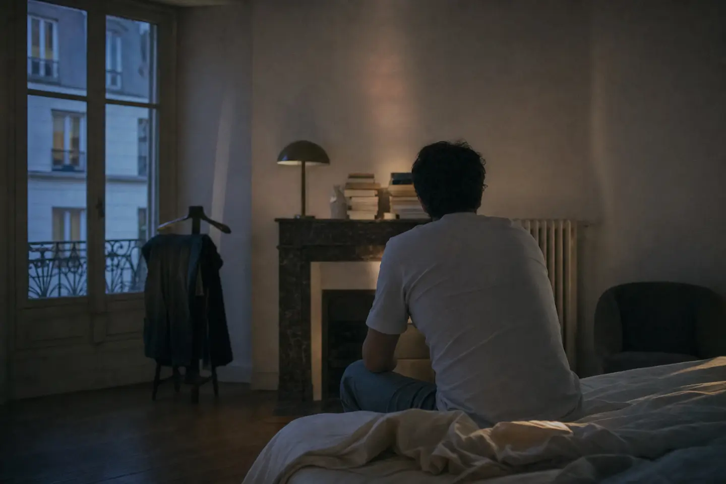 Personne éveillée la nuit sur le bord de son lit, gênée par le bruit provenant du logement voisin